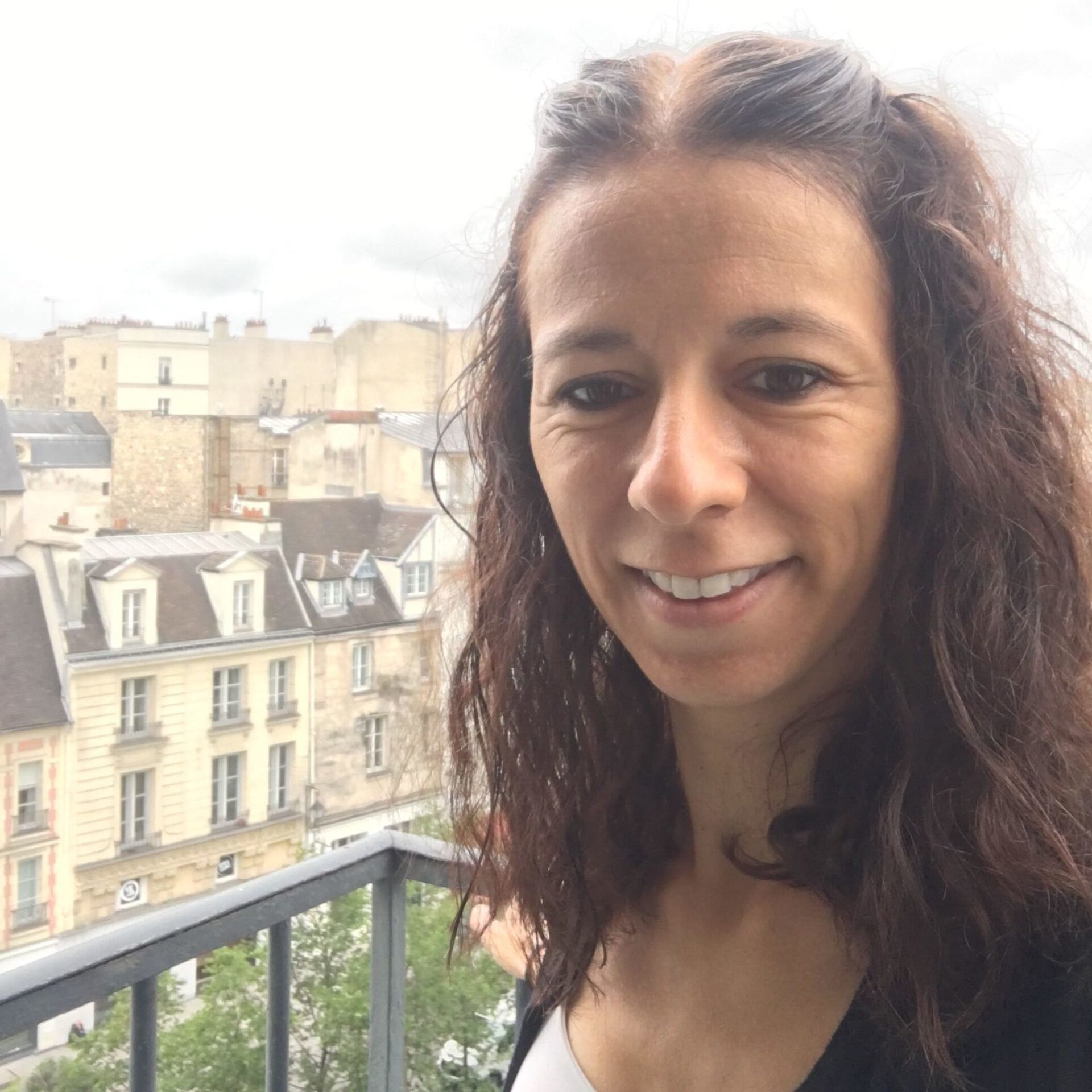 headshot of Emilia standing on a balcony