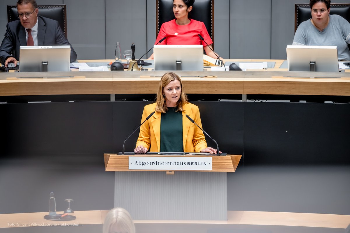 Oda Hassepaß steht am Redepult des Abgeordnetenhauses. Sie hat mittellange blonde Haare und trägt einen gelben Blazer. Ihr Blick ist ernst.