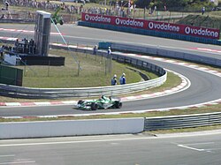 Photograph of Wilson driving his Jaguar into the pit