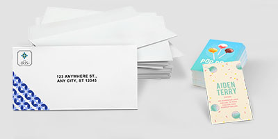 Custom printed envelopes and personalized business cards stacked on a white background.