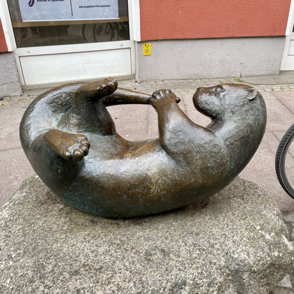 tempImagemMjDUY A bronze sculpture of an otter grabbing its own tail.