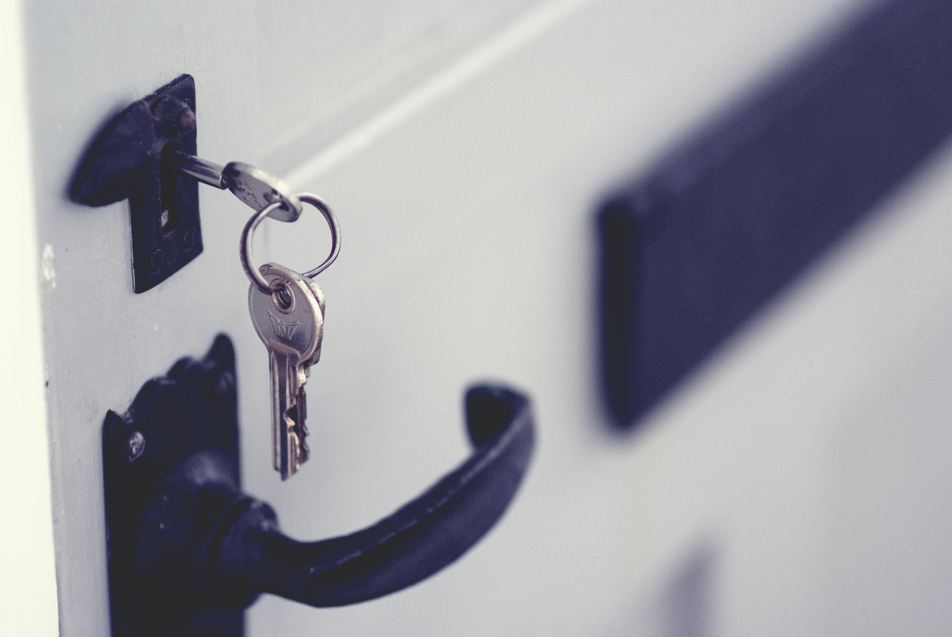 a photo of a set of keys left in a door lock, a visualization of a security vulnerability.