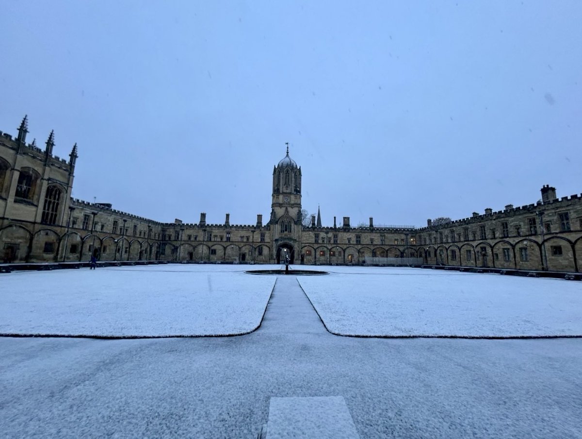 View of Tom Quad covered with snow at Christ Church, Oxford, with the Tom Tower in the background.
