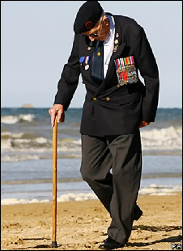 Un veterano camina por la playa de Arromanches