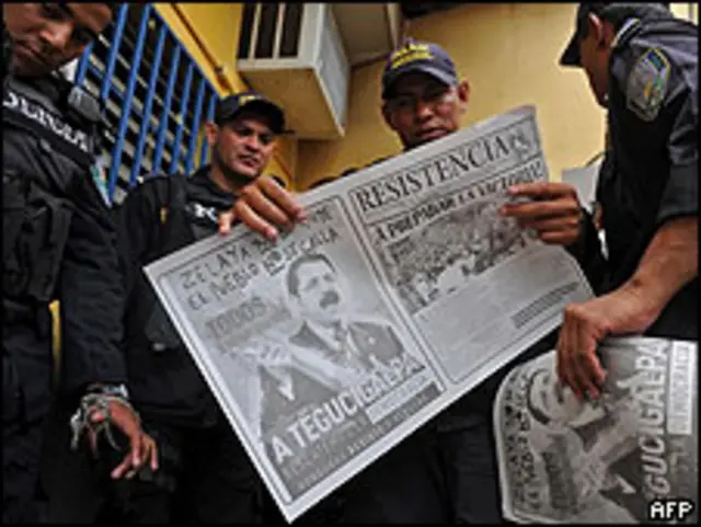 Policías hondureños leen los periódicos en Tegucigalpa