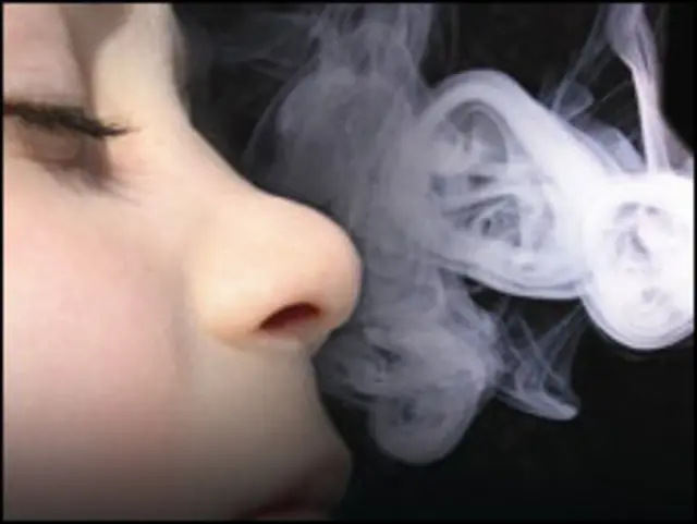Niño aspirando humo de cigarrillo.