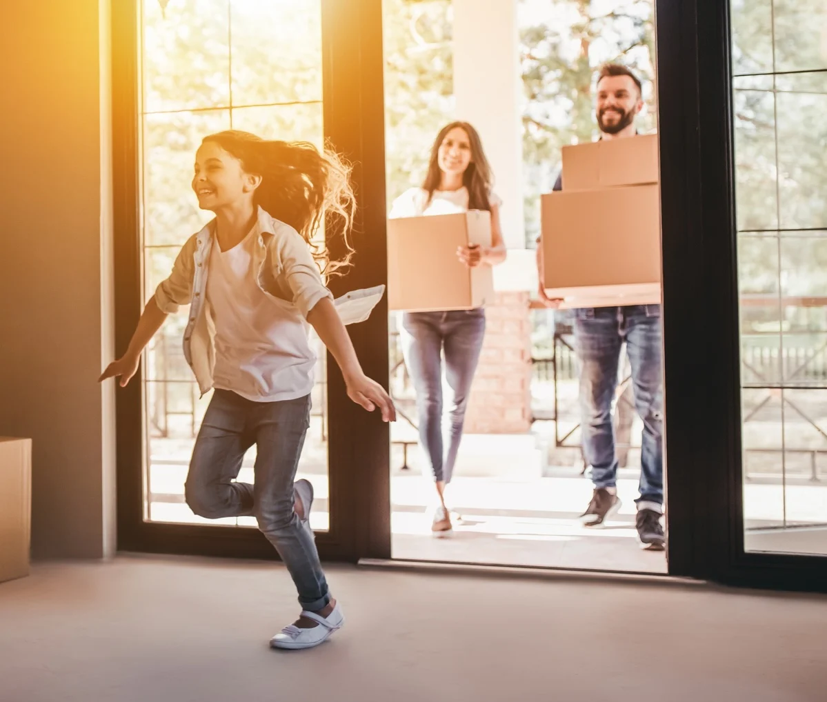 Happy smiling family with one child standing in new home on moving day.